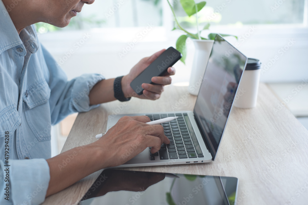 Aufkleber business man in smart casual wear using mobile phone during working on laptop computer with digital 