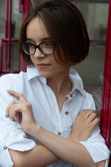 A young woman with short brown hair, wearing a white shirt