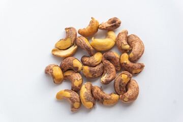 Close up of roasted cashew nuts with skin on white background. Cashew nuts salted with peel- rich in protein, antioxidants, and fiber.