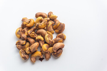 Close up of roasted cashew nuts with skin on white background. Cashew nuts salted with peel- rich in protein, antioxidants, and fiber.