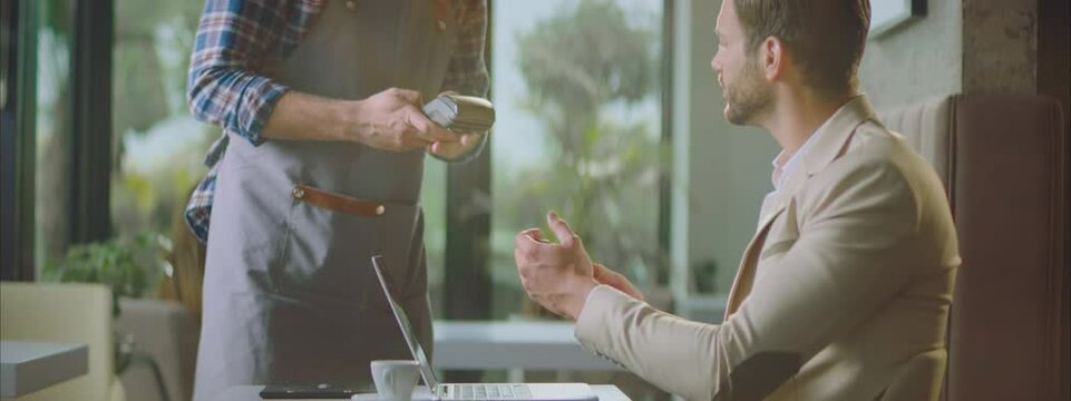 Man paying bill in cafe by modern contactless payment method. Using wireless technology. Entrepreneur working outside office.