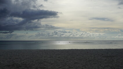 Mild sunset with soft fluffy clouds at a quiet beach in Saipan, Northern Mariana Islands.