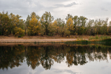 Fototapeta na wymiar autumn, a calm lake with a bank of yellow trees