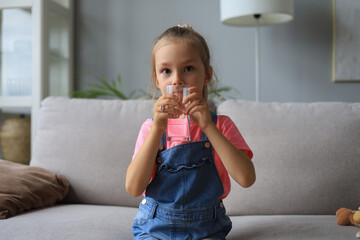 Happy little girl offer crystal still mineral water from glass, small child recommend daily dose of clean aqua.