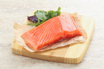 Raw salmon fillet over board