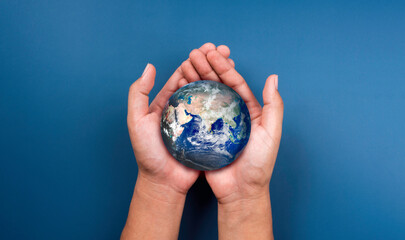 Earth in hands. World, small globe hold and supported by human hand with love and care, on blue...