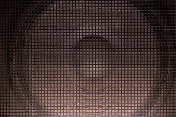 Vintage speaker behind a metal grille. Sound concept. Bass pattern for design.