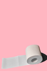 Toilet paper roll on a pink background. white soft roll unwound in the way of toilet paper.