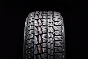 winter tire new friction velcro for safe driving in icy conditions on a black background front view