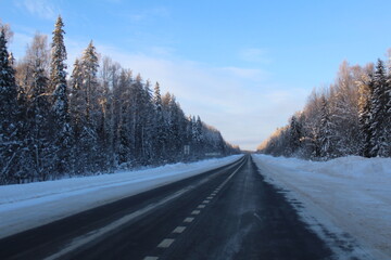 Fototapeta na wymiar winter highway the road among the snow-covered taiga forest