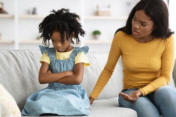 Family Misunderstanding. Offended black girl sitting on couch after quarrel with mom
