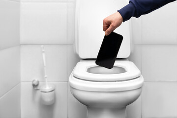 a man throws a mobile phone smartphone into the toilet with his hand. liberation from social...