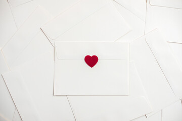 Valentine's day. Envelopes with red hearts. The holiday is February 14. Love letters in craft paper envelopes with red hearts. Romantic love letter for the Valentine's day concept. Space for text.
