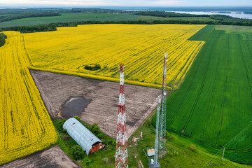 Aerial view video of telecommunication tower in the countryside farming fields with 4G, 5G cellular network antennas.