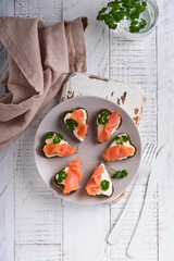 Mini sandwiches with salmon, curd cheese, parsley and rye bread in form of hearts. Valentine's day homemade creative food. Love breakfast design. Selective focus and copy space