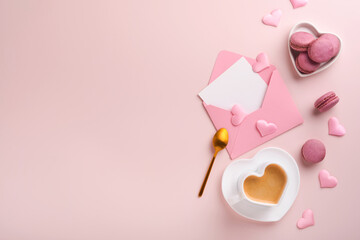 Valentines Day card. Pink empty envelope, macaron macaroon cookie and heart shaped coffee cup on pink background. 8 March, Womens Mothers Valentines Day, Birthday. Flat lay, top view, copy space.