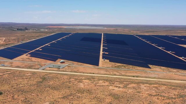 Aerial flying above solar panels energy farm in Australian outback as 4k.
