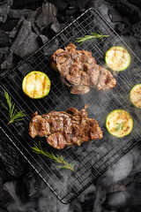Beef steak on the grill grate, flames on background. Barbecue and grill, delicious food.
