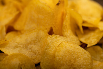 Potato chips scattered on the table, close-up, selective focus.