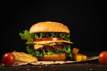 Homemade beef burgers and french fries on dark background.