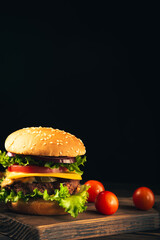 Homemade beef burgers and french fries on dark background.