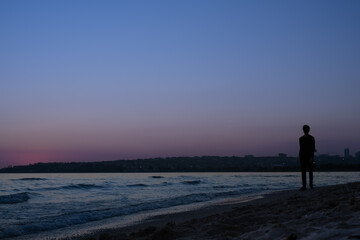 Fototapeta na wymiar Silhouette of a person walking on the beach.