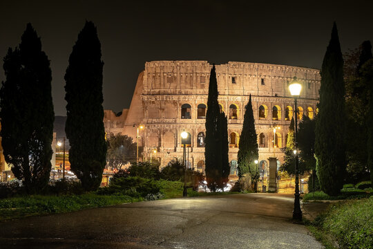 Ancient monument Colosseo at night viewed from the park