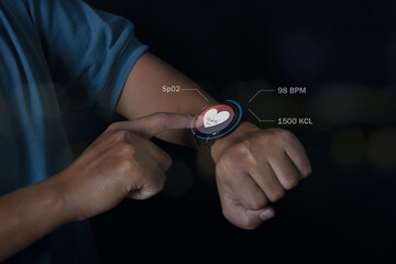 Man using smart watch technology checking heart rate with health app icon on the screen. Holographic icon user interface. Futuristic smart watch technology.