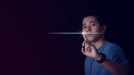 Close up of young man touching digital screen with finger on dark background. Innovation technology internet and business concept.