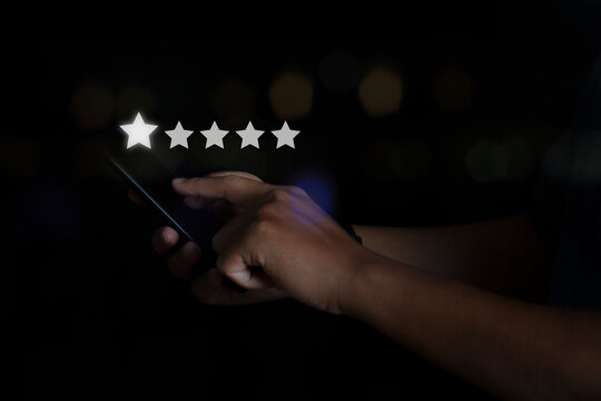 Businessman use smartphone choosing screen on five star icon to give satisfaction in service rating very impressed. Customer service experience.
