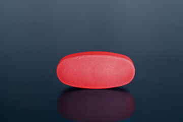 Red pill on black background