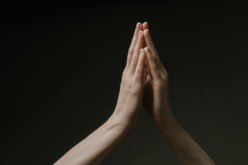 Praying hands to God in the dark. Woman hands reaching out to God or for help in barokko style