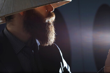 A bearded man in a suit holds an object in his hand. Concept of time and ideas. Aspiration and development.