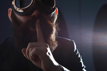 A bearded man in a suit holds an object in his hand. Concept of time and ideas. Aspiration and development.