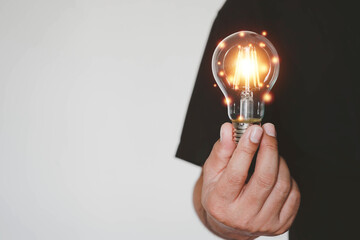 hand holding light bulb. idea concept with innovation and inspiration, ideas of new ideas with...