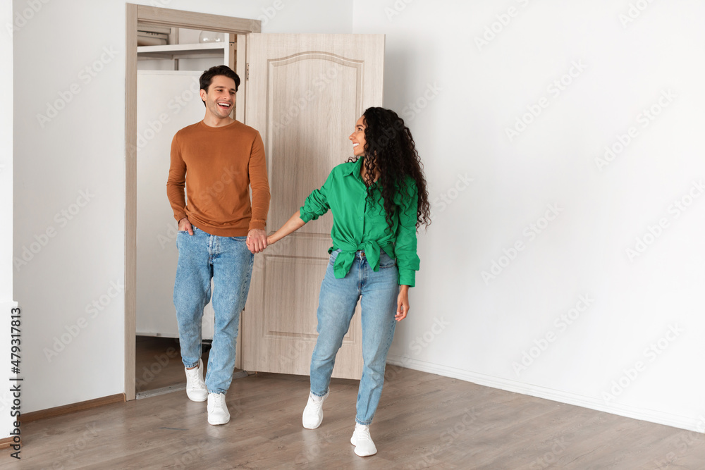 Wall mural happy woman inviting guy to enter home