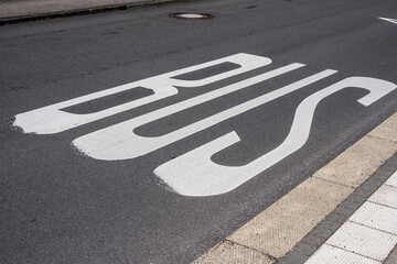 road marking with white letters at a bus stop