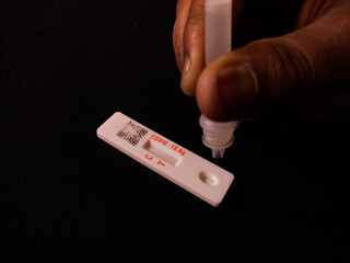 covid19 or novel coronavirus omicron test in rapid antigen method. hand dripping extracted antigen...