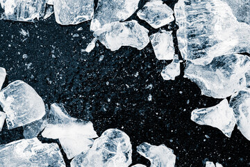Pieces of scattered crushed ice cubes black background. Ice pieces pattern.