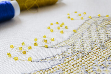 A fragment of work in the technique of gold embroidery with beads and metallic threads