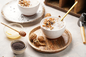 Traditional east european (ukrainian, polish, belarusian) religious christmas dish kutia made of wheat, poppy seeds, honey, walnuts and dried berries. modern style in porcelain bowls, wooden plates