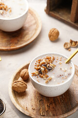 Traditional east european (ukrainian, polish, belarusian) religious christmas dish kutia made of wheat, poppy seeds, honey, walnuts and dried berries. modern style in porcelain bowls, wooden plates