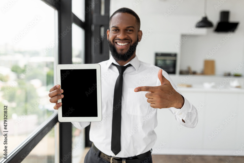 Poster happy black guy showing tablet with blank empty screen, mockup