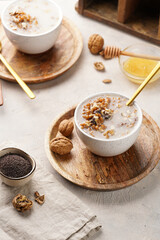 Traditional east european (ukrainian, polish, belarusian) religious christmas dish kutia made of wheat, poppy seeds, honey, walnuts and dried berries. modern style in porcelain bowls, wooden plates