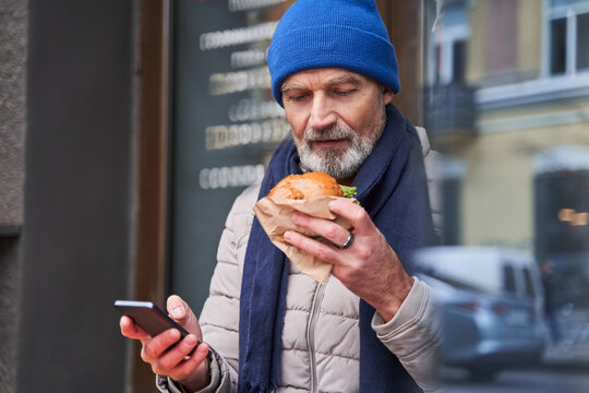 Retirement guy preparing eating his tasty sandwich while spending time at the cafe