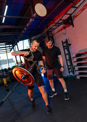 Fototapeta na wymiar Two muscular mitivated athletes working hard. Strong men training hard in the gym.