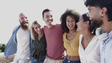United group of multiracial happy friends hugging each other while walking in city street - Unity, community and diversity concept. High quality 4k footage
