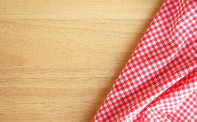 Crumple pink plaid fabric or tablecloth at the corner of wood desk with copy space