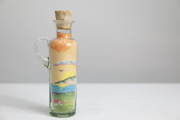 Small glass jar with a drawing of a landscape made with colored sand, 
used to decorate your home