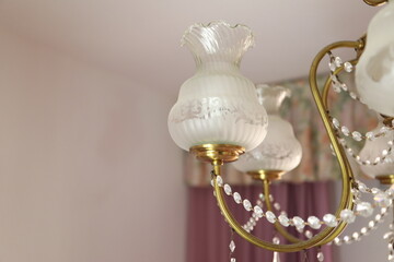 Bedroom crystal chandelier with chains that pretend to be diamonds, 
which are out of focus